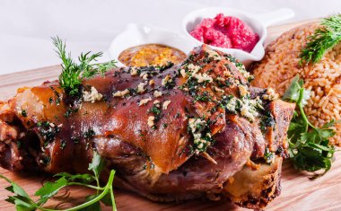 Alman usulü kavrulmuş domuz paçası (eklem, bacak) ve tahta kesme tahtasında pirinç.