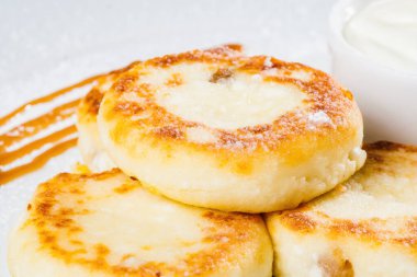 Kahvaltıda. Beyaz tabakta ekşi kremalı süzme peynirli krep.