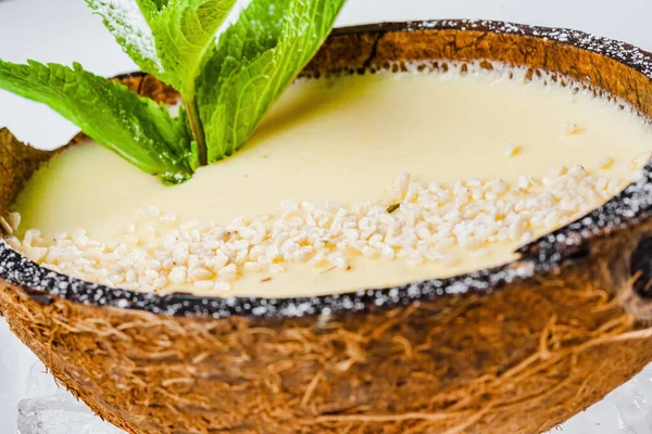 Italiaans Dessert Panna Cotta Met Sesamzaadjes Muntblaadjes Geserveerd Halve Kokosnoot — Stockfoto