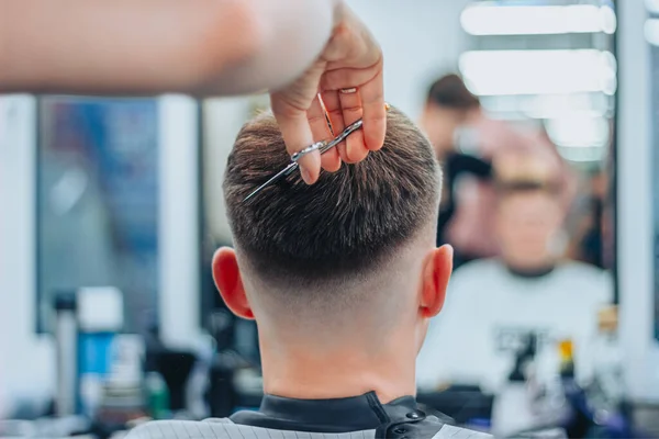 A tattooed woman hairdresser cuts guys hair — Stock Photo, Image