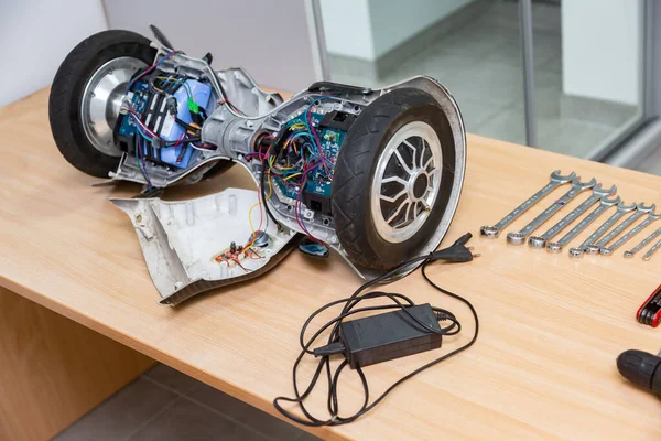 Gyro scooter elektrikli scooter, aletlerin yanındaki tamir için masaya söküldü. Yatay oryantasyon. Yüksek kalite fotoğraf