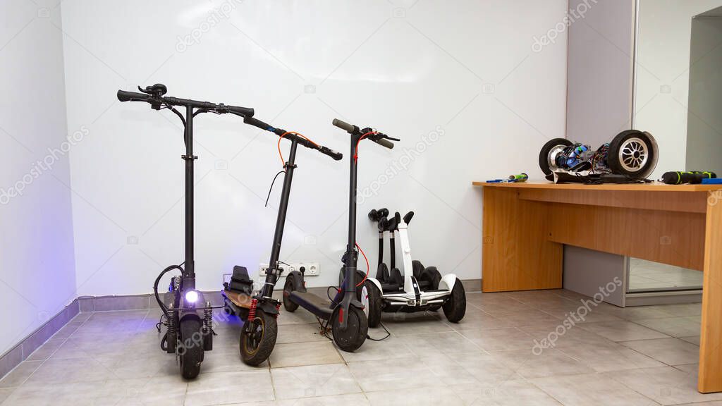 Electric scooters, gyro scooters stand in a bright service room for the repair of electrical equipment. Horizontal orientation. High quality photo
