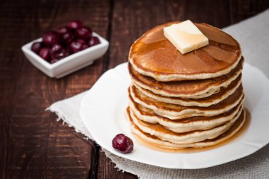 kiraz ve karanlık bir arka plan üzerine tereyağı ile Pancakes