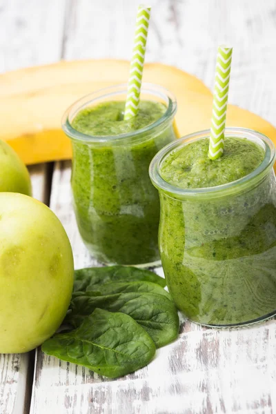 Batido verde con manzana, plátano y espinacas sobre un fondo claro —  Fotos de Stock