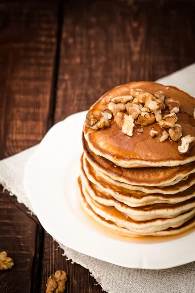 Pannkakor med nötter och honung på en mörk bakgrund — Stockfoto