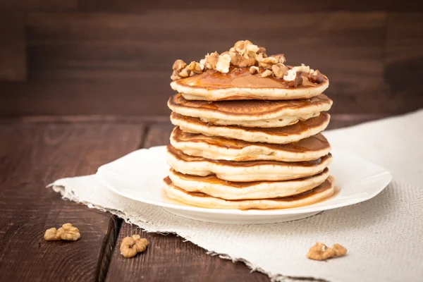 Pannkakor med nötter och honung på en mörk bakgrund — Stockfoto