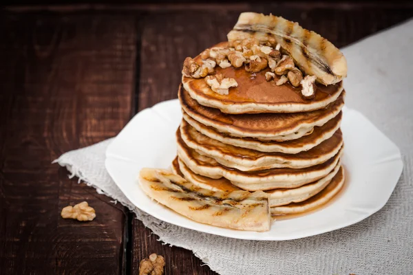 Pannkakor med grillad banan och nötter på en mörk bakgrund — Stockfoto