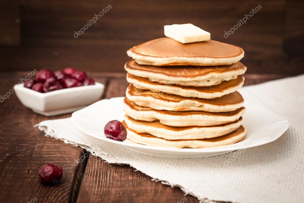 pancakes with cherry and butter on a dark background