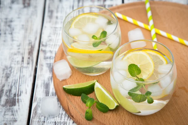 Cóctel fresco con soda, lima y limón sobre fondo de madera — Foto de Stock