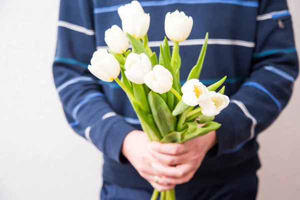 Man holding bouquet of white tulips for a woman. Mothers day, Wo