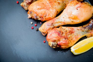 Siyah arka plan üzerine Fesleğenli kızarmış tavuk budu