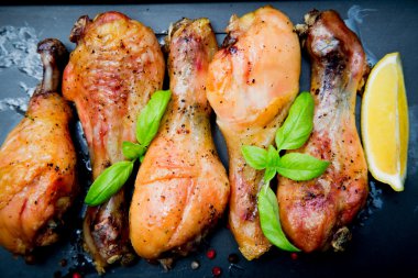 Siyah arka plan üzerine Fesleğenli kızarmış tavuk budu