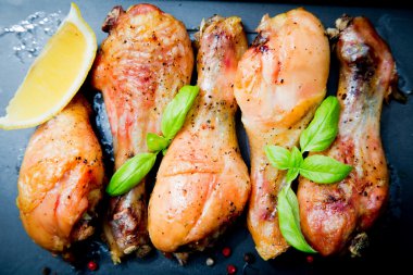 Siyah arka plan üzerine Fesleğenli kızarmış tavuk budu