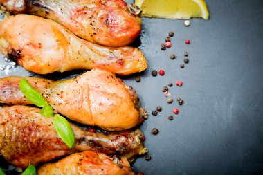 Siyah arka plan üzerine Fesleğenli kızarmış tavuk budu