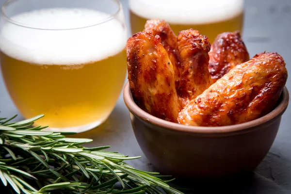 Sült csirke szárny, sör, egy sötét szürke háttér. — Stock Fotó