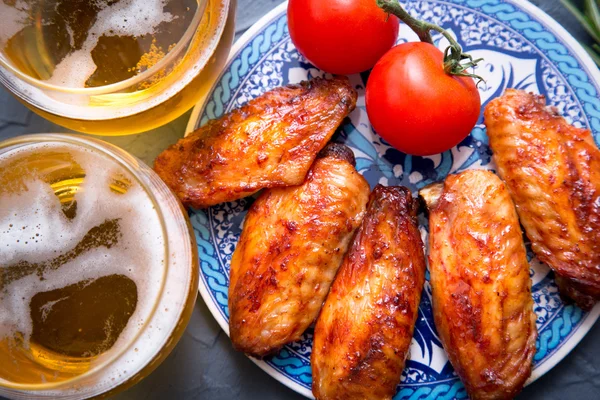 Sült csirke szárny, sör, egy sötét szürke háttér. — Stock Fotó