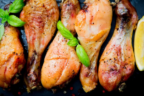 Siyah arka plan üzerine Fesleğenli kızarmış tavuk budu