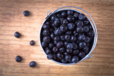 Ahşap masa arka plan üzerinde yaban mersini. Olgun ve sulu taze seçici