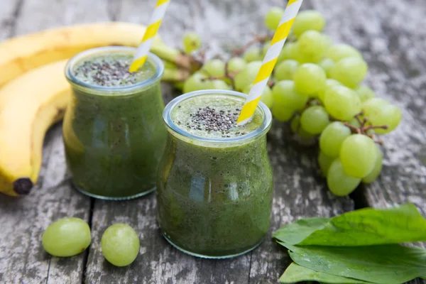 Smoothie verde desintoxicación saludable con espinacas, uva, plátano y semillas de chía en la vieja mesa de madera —  Fotos de Stock