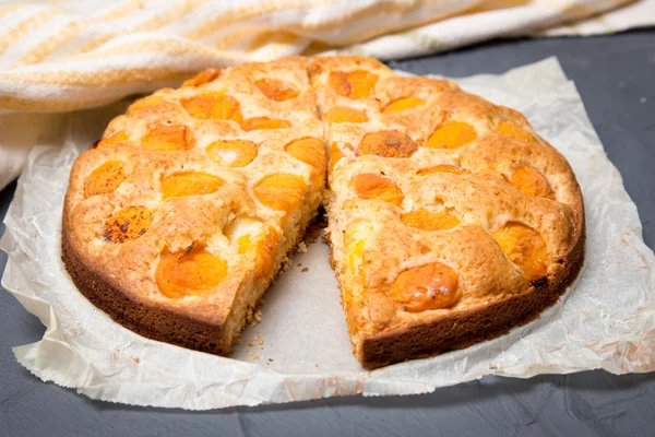 Apricot pie on the baking paper with ripe apricots Stock Photo