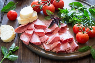 Meze jambon, bresaola ve salam. ekmek, domates ve fesleğen