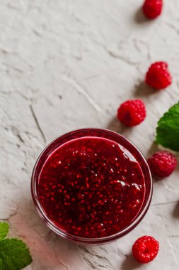 Beton zeminde ev yapımı ahududu reçeli taze ahududu ve seçici bir odak noktası var..