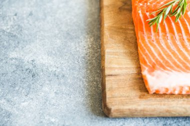 Somon balığı. Pişirme malzemeleri, otlar ve limonla taze çiğ somon balığı filetosu. Kapatın. sağlıklı yemek, diyet veya yemek pişirme konsepti