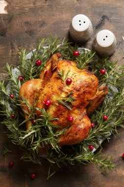 ahşap bir arka planda, biberiyeli sarımsaklı ve kızılcıklı tavuk pişirdim. Kızarmış tavuk..