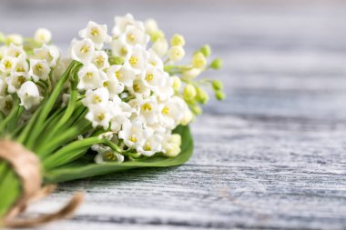 Mavi tahta üzerinde vadi zambakları buketi