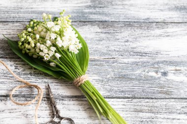 Mavi tahta üzerinde vadi zambakları buketi