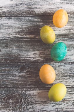 Eski ahşap arka planda renkli paskalya yumurtaları
