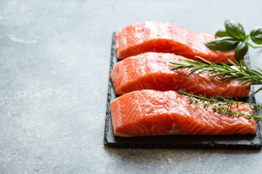 Somon balığı. Pişirme malzemeleri, otlar ve limonla taze çiğ somon balığı filetosu. Kapatın. sağlıklı yemek, diyet veya yemek pişirme konsepti