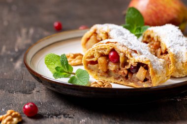 Elma ve tarçınlı ev yapımı meyveli börek ahşap bir arka planda, metin için yeri olan bir tabakta.,