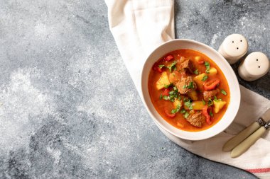 Gulaş, sığır eti, patates, domates ve biberli geleneksel bir Macar yemeğidir. Gulaş, beyaz tabakta ve sebzeli..