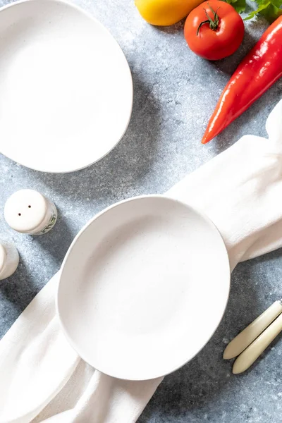 Boş tabaklar ve gri arka planda peçete. Gıda hazırlama ve kişisel bakım kavramı.