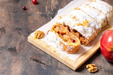 Elma ve tarçınlı ev yapımı meyveli börek ahşap bir arka planda, metin için yeri olan bir tabakta.,