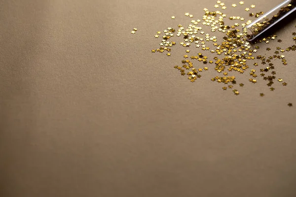 Golden sparkles stars on gold holiday background. Festive backdrop for your projects
