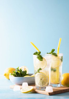 İki bardak limonata ya da naneli mojito kokteyli soğuk, ferahlatıcı içecek ya da buzlu mavi arka plan. Boşluğu kopyala.