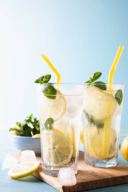 İki bardak limonata ya da naneli mojito kokteyli soğuk, ferahlatıcı içecek ya da buzlu mavi arka plan. Boşluğu kopyala.