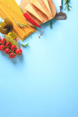 Mavi arka planda pişmemiş makarna. Üst Manzara. Pişirmek için malzemeli çiğ makarna. Yemek konsepti. İtalyan yemeği..