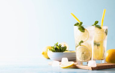 İki bardak limonata ya da naneli mojito kokteyli soğuk, ferahlatıcı içecek ya da buzlu mavi arka plan. Boşluğu kopyala.