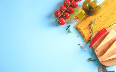 Mavi arka planda pişmemiş makarna. Üst Manzara. Pişirmek için malzemeli çiğ makarna. Yemek konsepti. İtalyan yemeği..