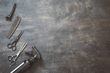 Koyu ahşap arka plan görünümlü ve taraklı profesyonel kuaför araçları seti.