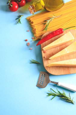 Mavi arka planda pişmemiş makarna. Üst Manzara. Pişirmek için malzemeli çiğ makarna. Yemek konsepti. İtalyan yemeği..