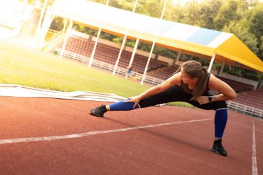 Genç atletik kadın esneyip koşmaya hazırlanıyor. güçlü sporcu kadın