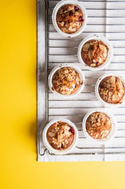 Sarı arka planda fırında pişirme rafında ev yapımı kekler. Metnin için yer, düz yat