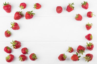 Çilek Beyaz ahşap zemin üzerine yeşil yaprak ile
