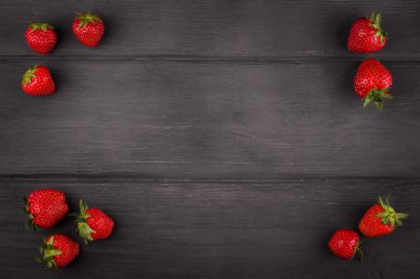 Çilek koyu ahşap zemin üzerine yeşil yaprak ile