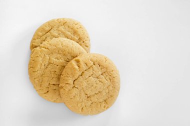 Fıstık ezmeli kurabiyeler beyaz arka planda doğal ışık altında düzenlenmiştir..