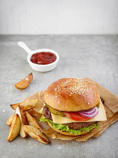 Cheeseburger e fatias de batata — Fotografia de Stock